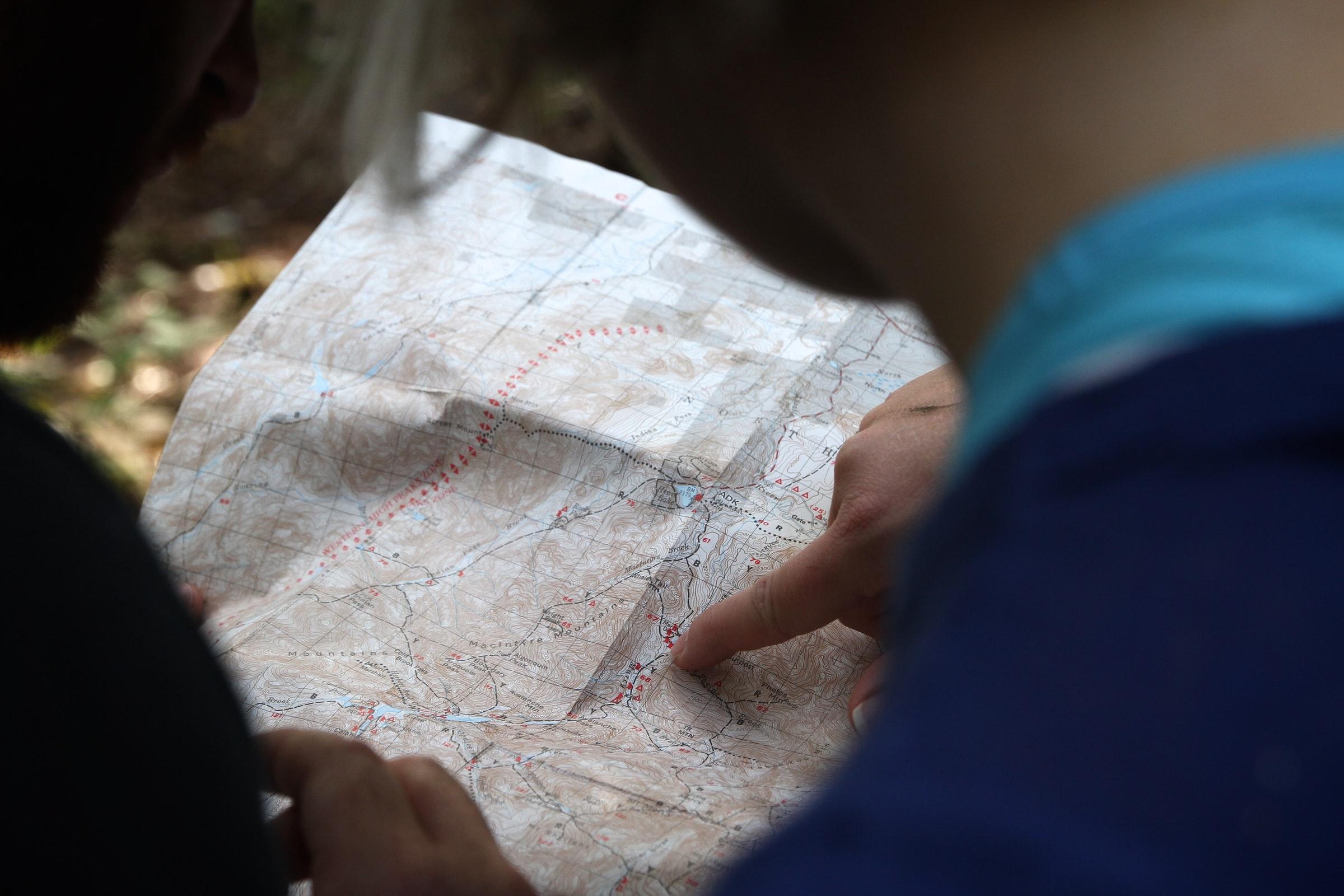 A person pointing at a beige map